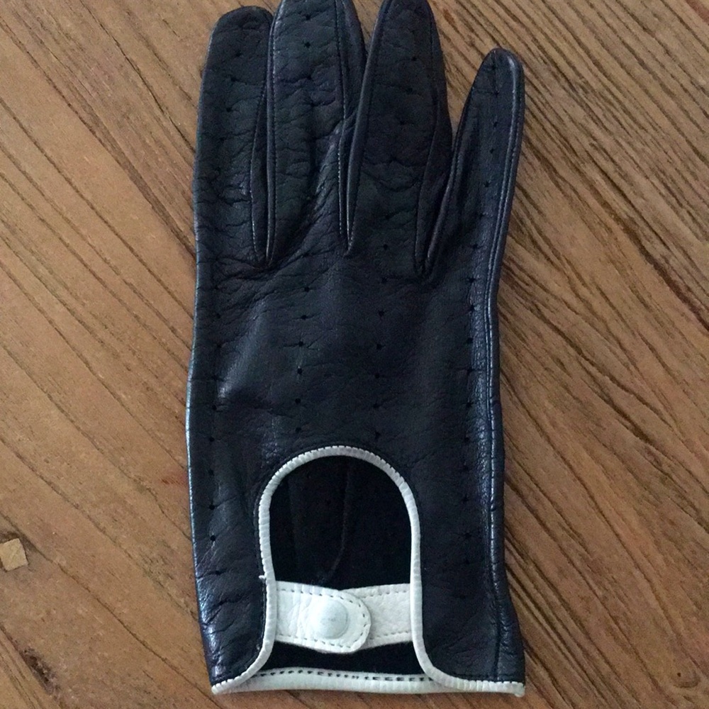 Perforated unlined black leather driving gloves. White trim. Snap front